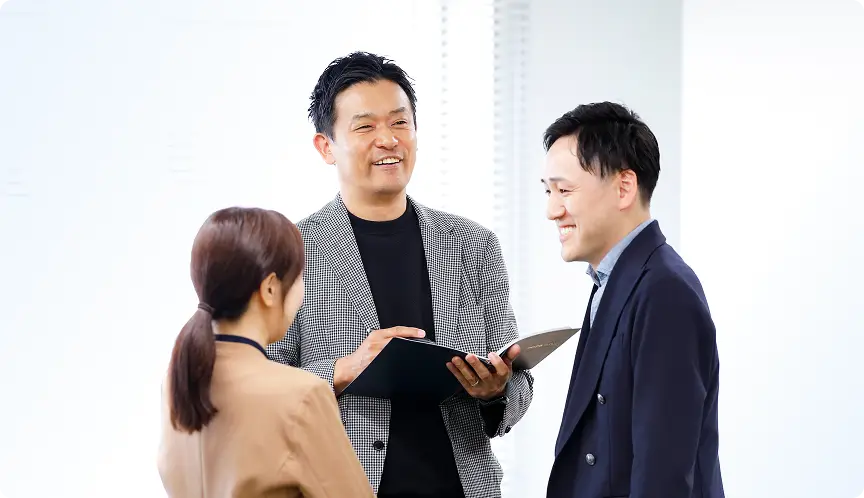 スーツ姿のビジネスパーソンが会話する様子